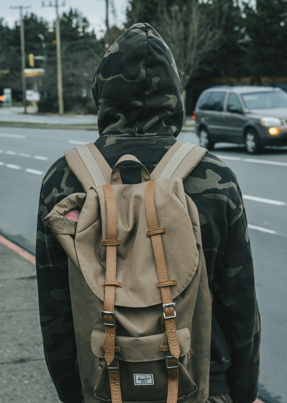 person wearing gray knapsack bag and hoodie jacket during daytime