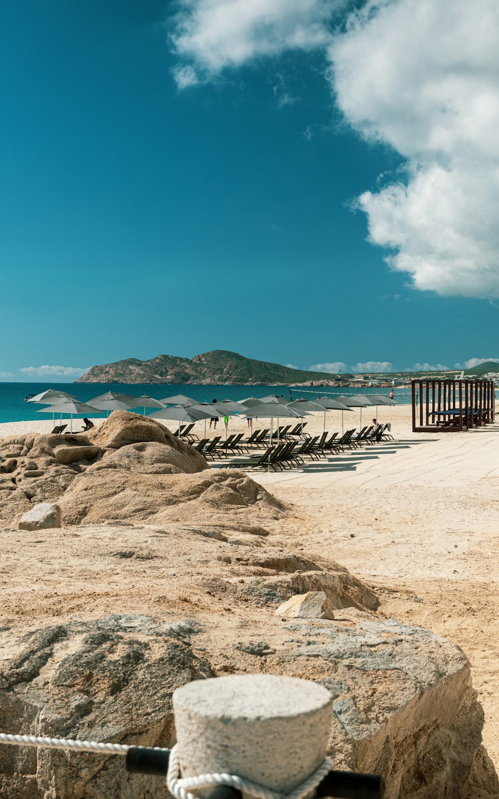 a sandy beach next to a body of water