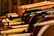 A close-up view of multiple violins arranged side by side, with their bows resting on top. The warm wooden tones create an artistic composition, emphasizing the craftsmanship of the instruments.