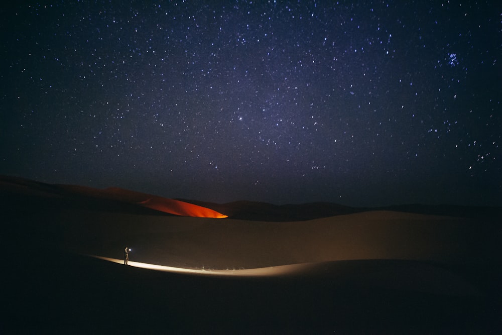 밤에 사막 한가운데에 서 있는 사람