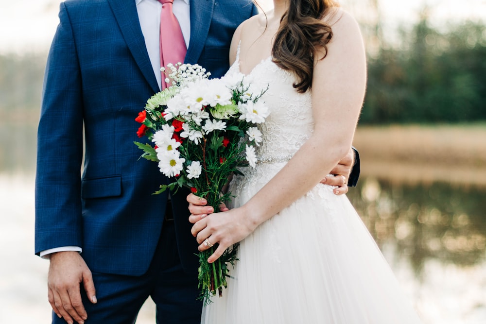 woman holding white-petaled flower bouquet