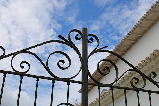 A skilled technician repairing a sturdy iron gate under a bright sunny sky in La Quinta.