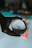 A hand is holding a crystal ball, through which a busy public market sign is viewed in a distorted, artistic manner. The background is blurred with bokeh lights, creating a dreamy and reflective ambiance.