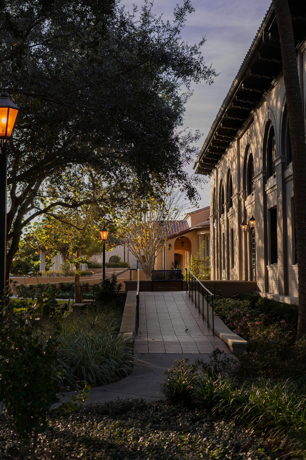 a walkway leading to a building with a lamp post