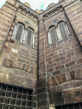 Close-up of intricate heritage building facade highlighting ornate stonework and vintage windows.