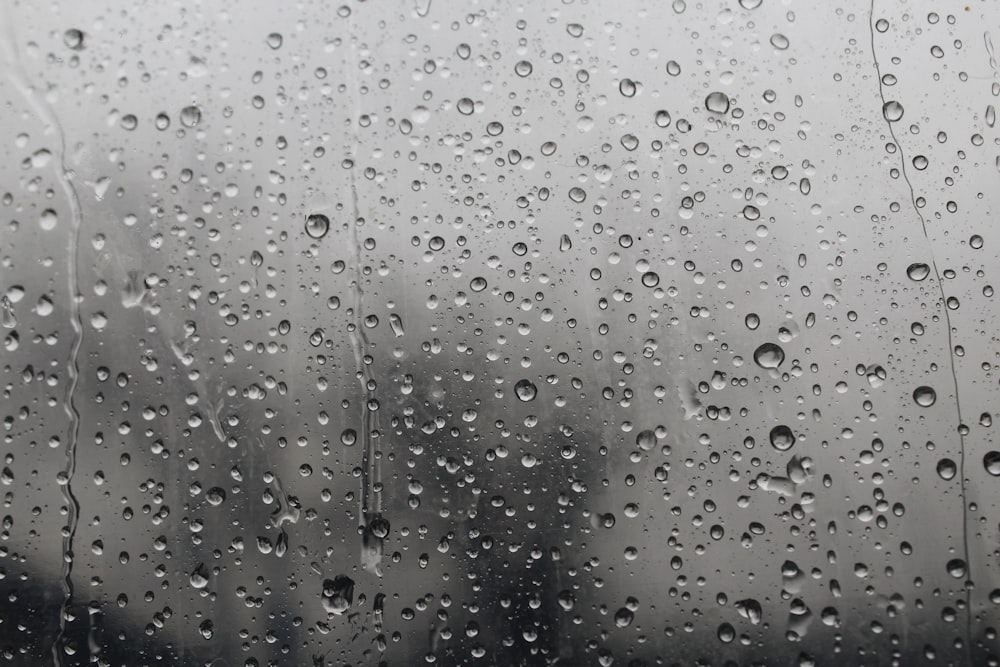 Gotas de lluvia en una ventana con edificios al fondo