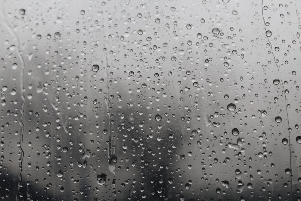 rain drops on a window with buildings in the background