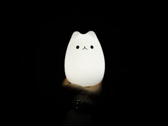 Close-up of a 3D printed litophany lamp featuring a detailed anime character design glowing softly in a dark room