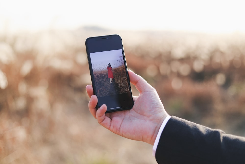 person holding smartphone displaying woman