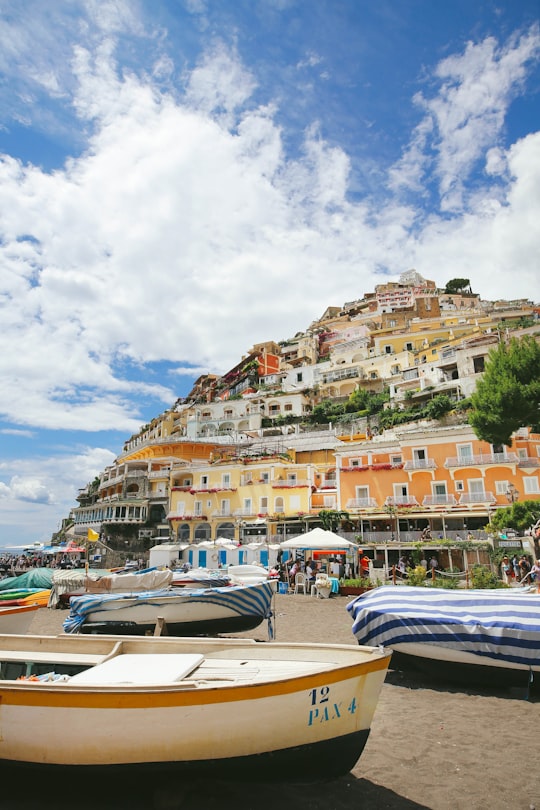 houses and buildings near mountain cliff under white and blue sky in Amalfi Coast Italy