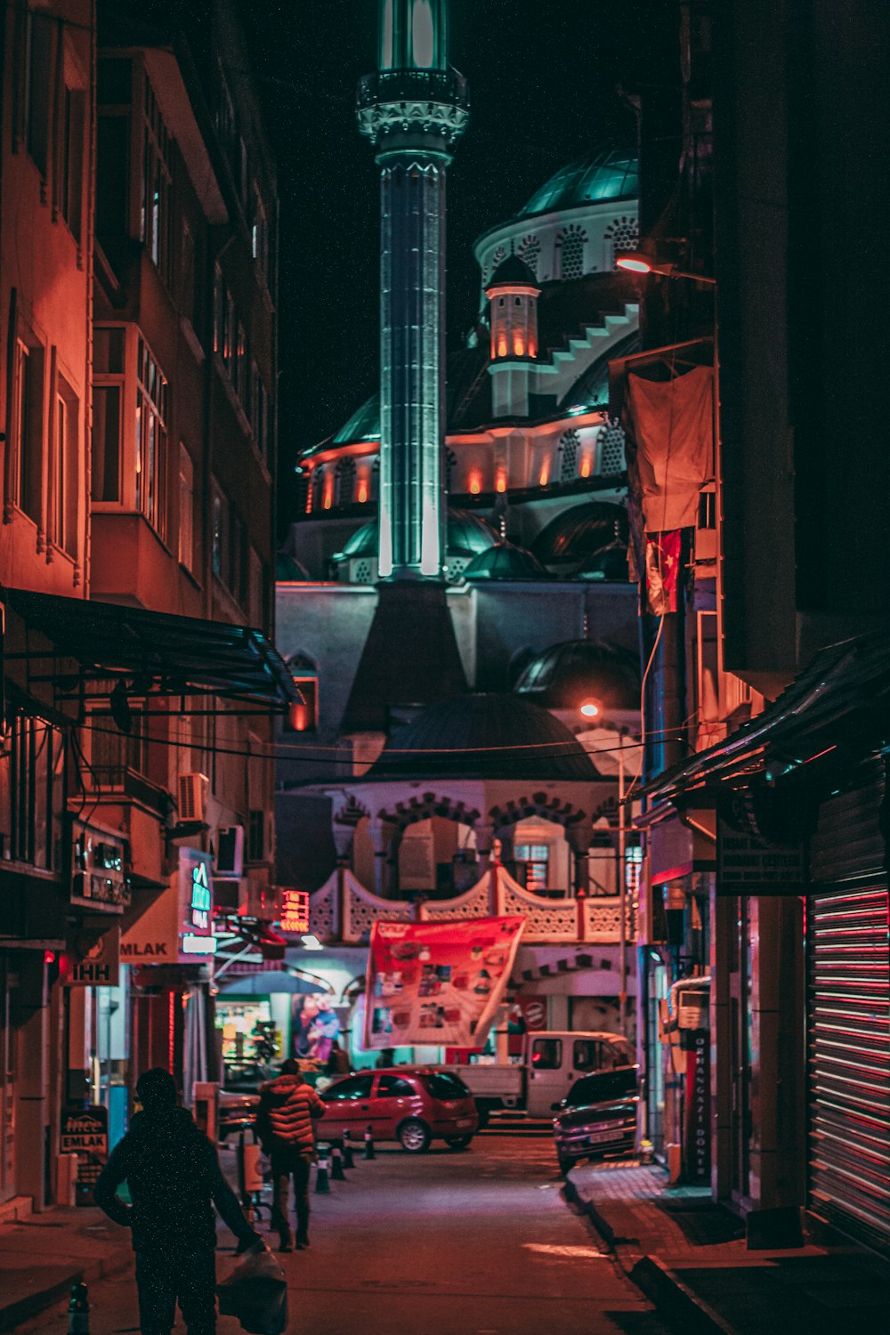 people walking on street between buildings at night