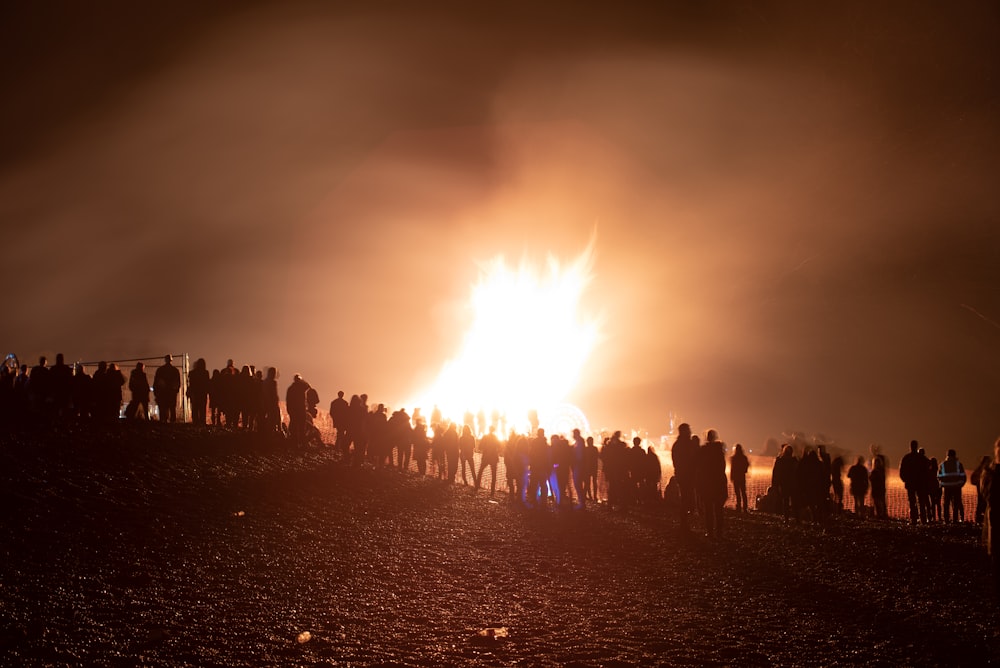 people watching large bonfire during night