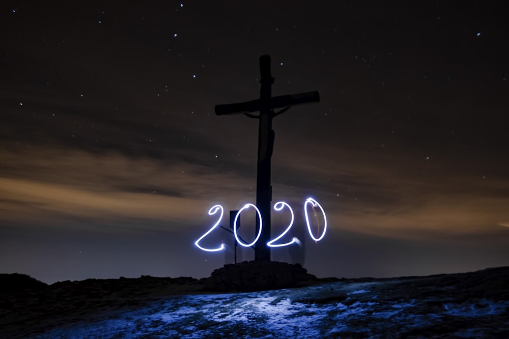 a cross on top of a hill with a sky background