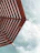A perspective of a wooden pergola with slatted beams set against a partly cloudy sky.