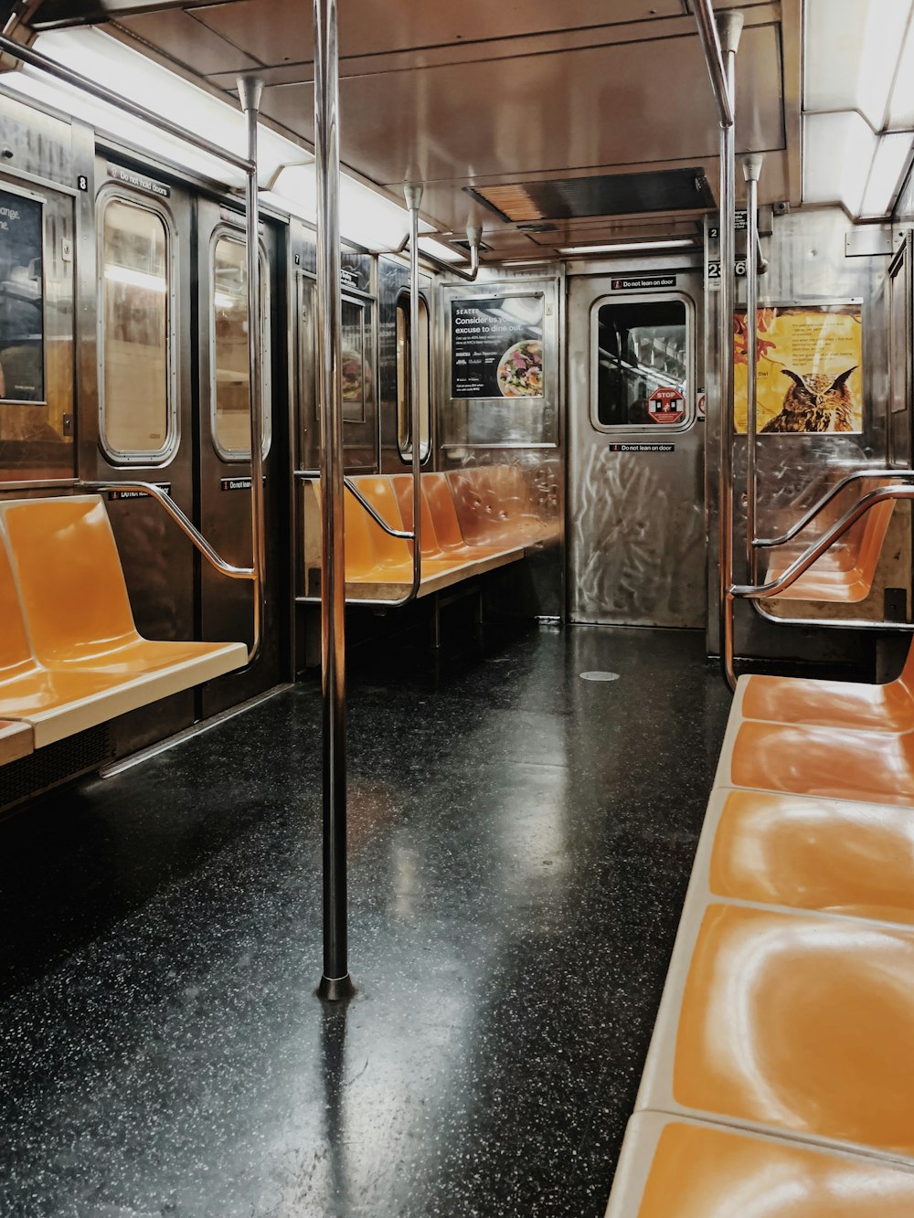 a subway car with orange seats and metal railings