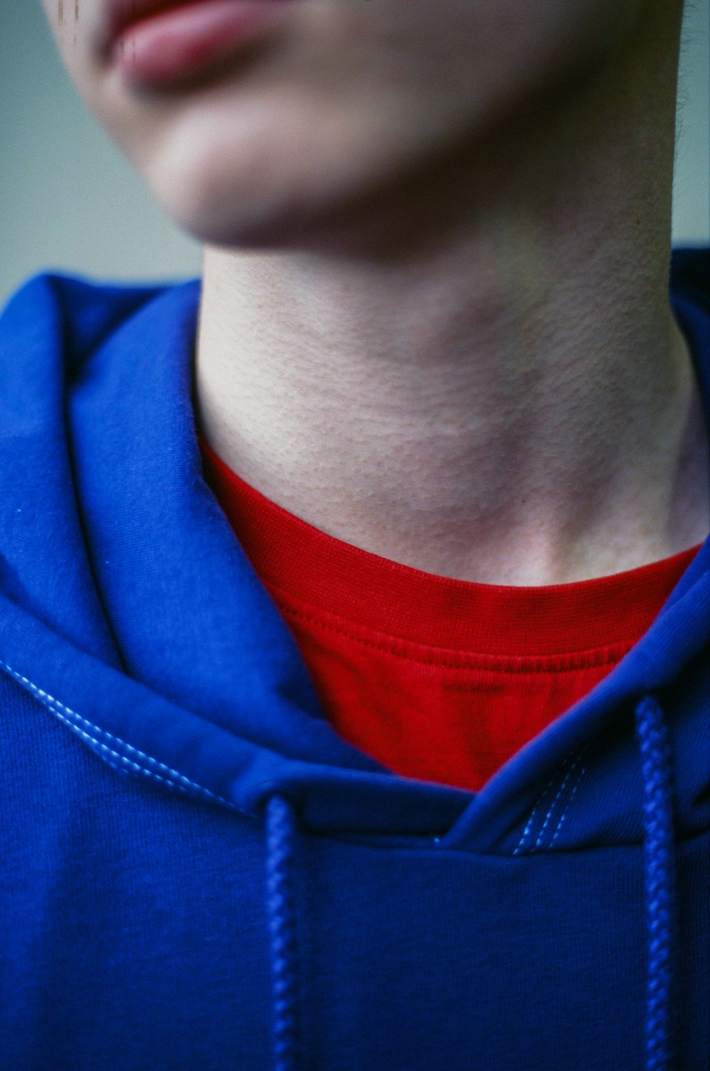 man wearing red crew-neck top and blue pullover hoodie