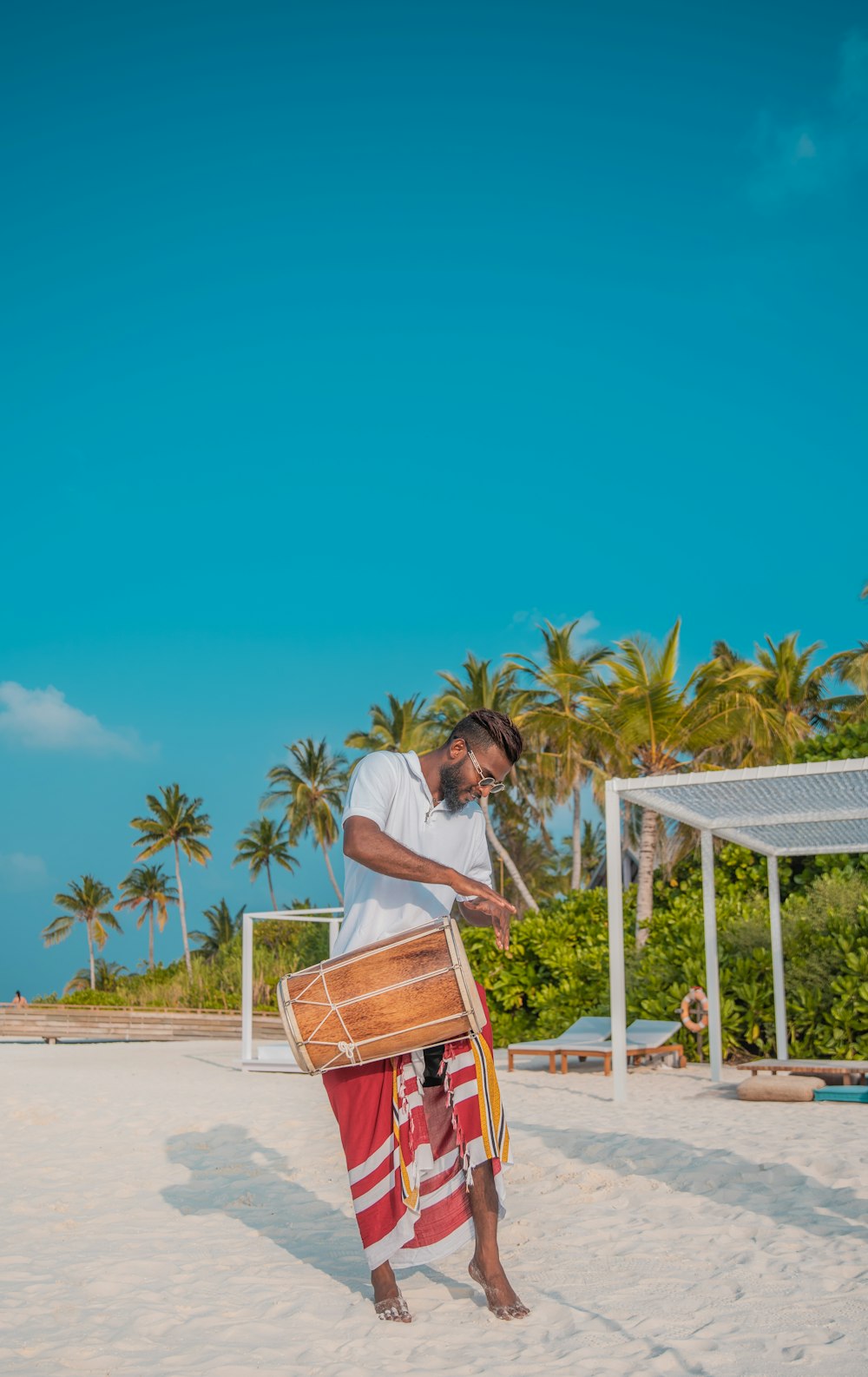 homme portant un tambour brun sur la plage