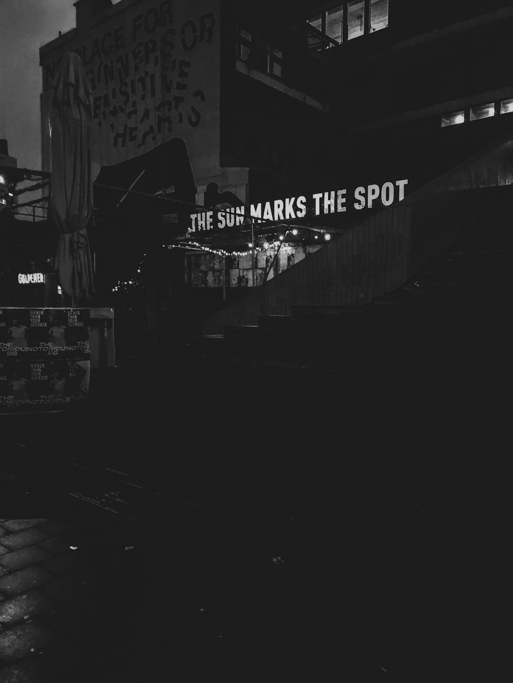 grayscale photography of the sun marks the spot printed building