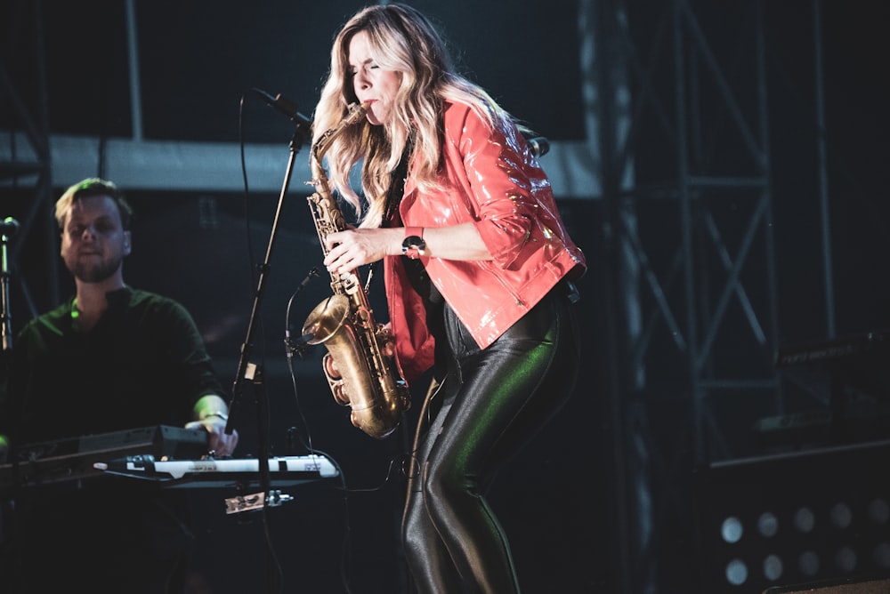 woman standing while playing saxophone