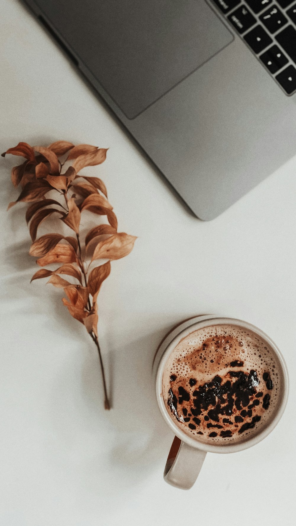 a cup of coffee next to a laptop computer