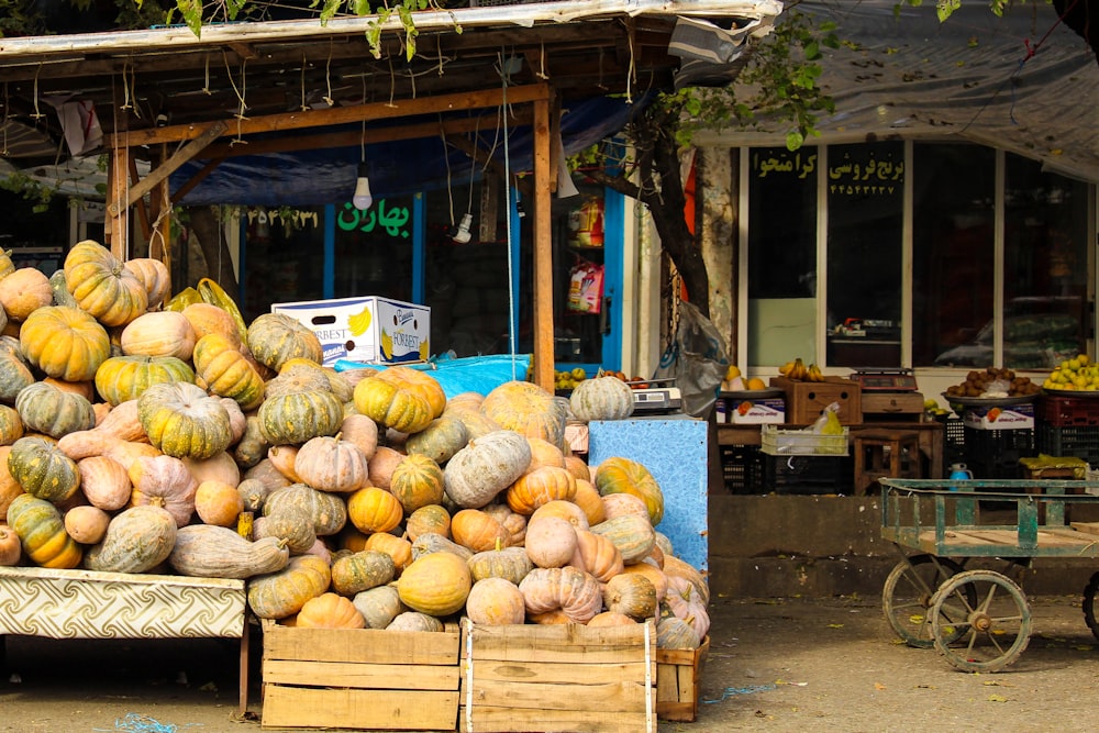 calabaza naranja y amarilla en cajas de madera marrones cerca de la tienda