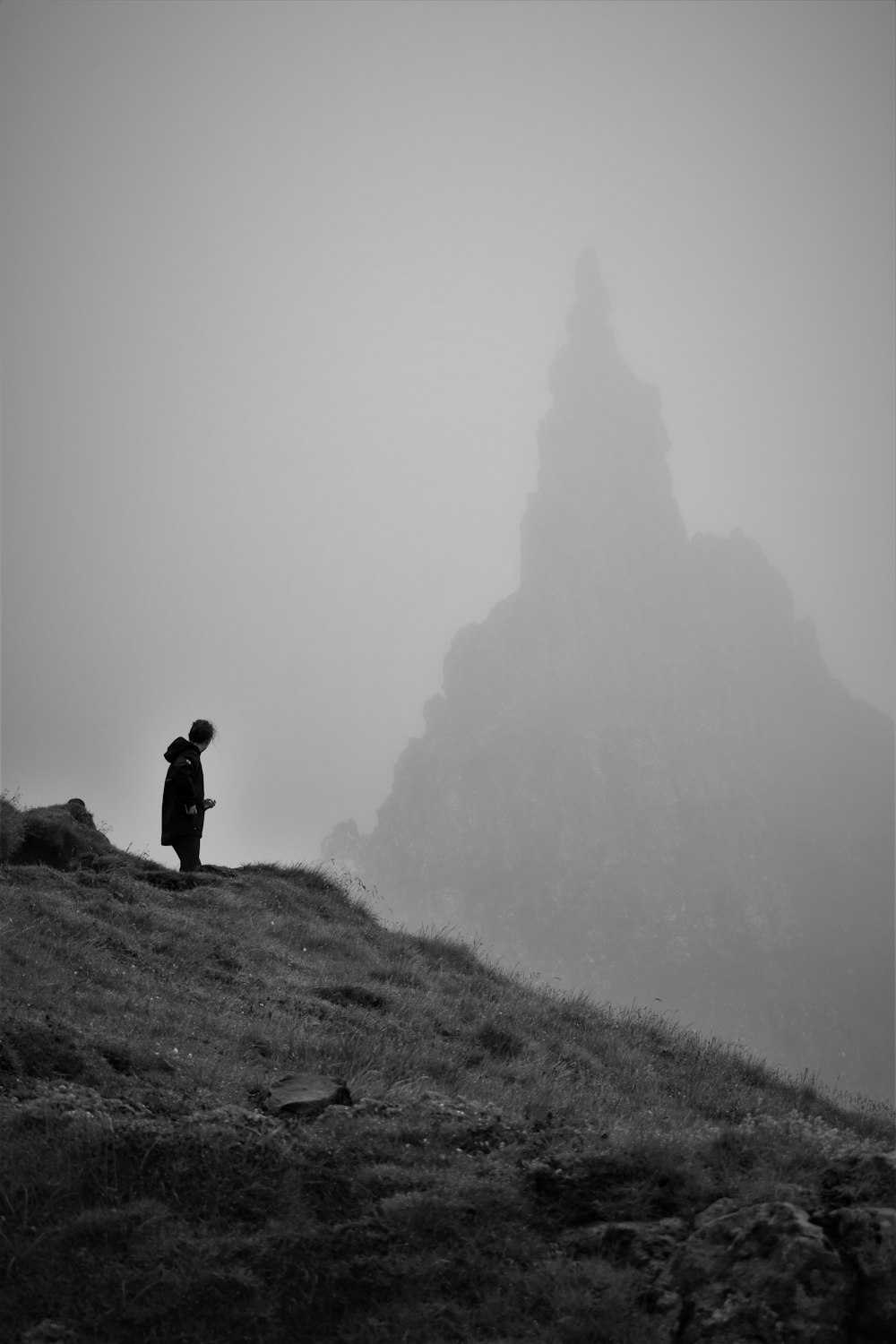 a person standing on top of a grass covered hill