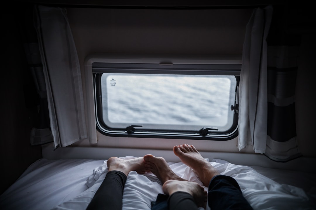 two person lying on white bed