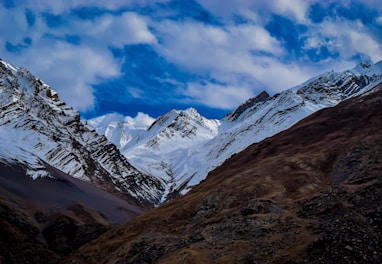 summit view of mountain covered with snow under white and blue sky