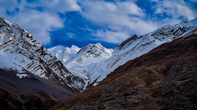 summit view of mountain covered with snow under white and blue sky