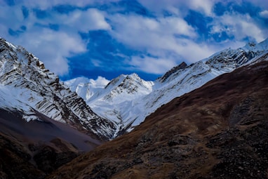 summit view of mountain covered with snow under white and blue sky