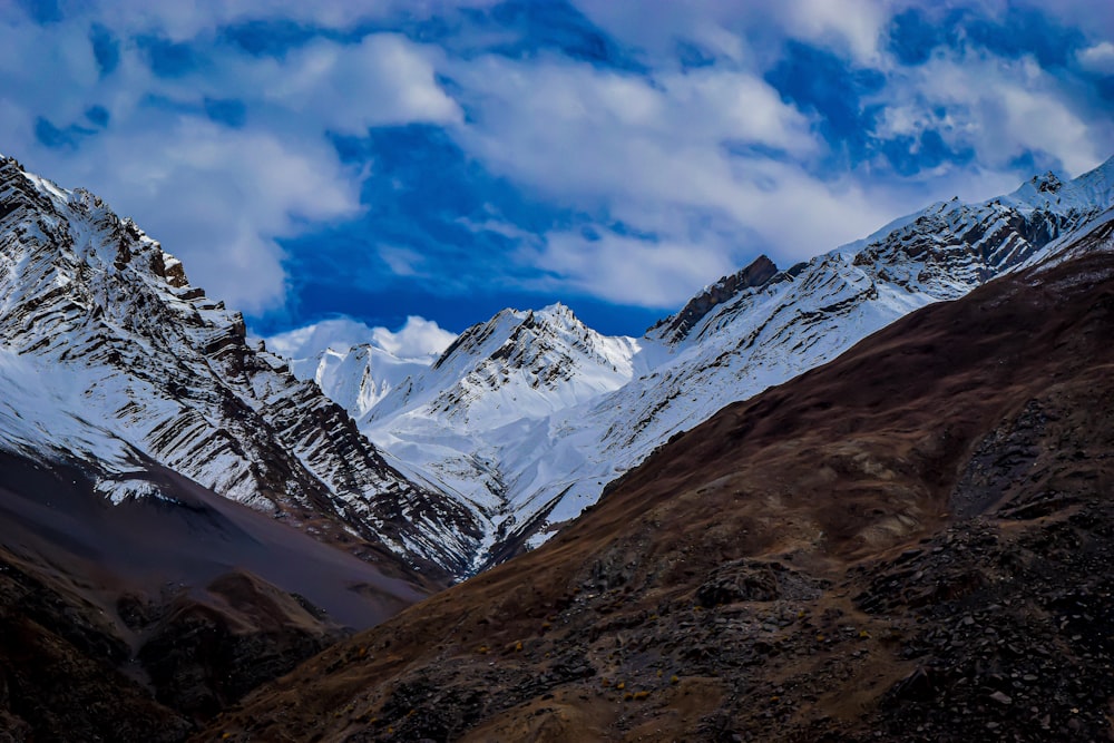 summit view of mountain covered with snow under white and blue sky