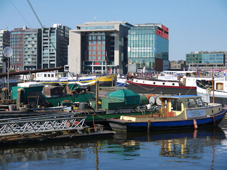 A vibrant waterfront scene in Portuguesa with boats docked and tourists enjoying the sunny day.