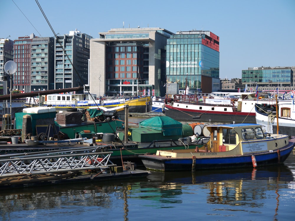 different boats on body of water near city with high-rise buildings during daytime