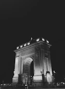 Nighttime illumination highlighting the monument’s architectural details.