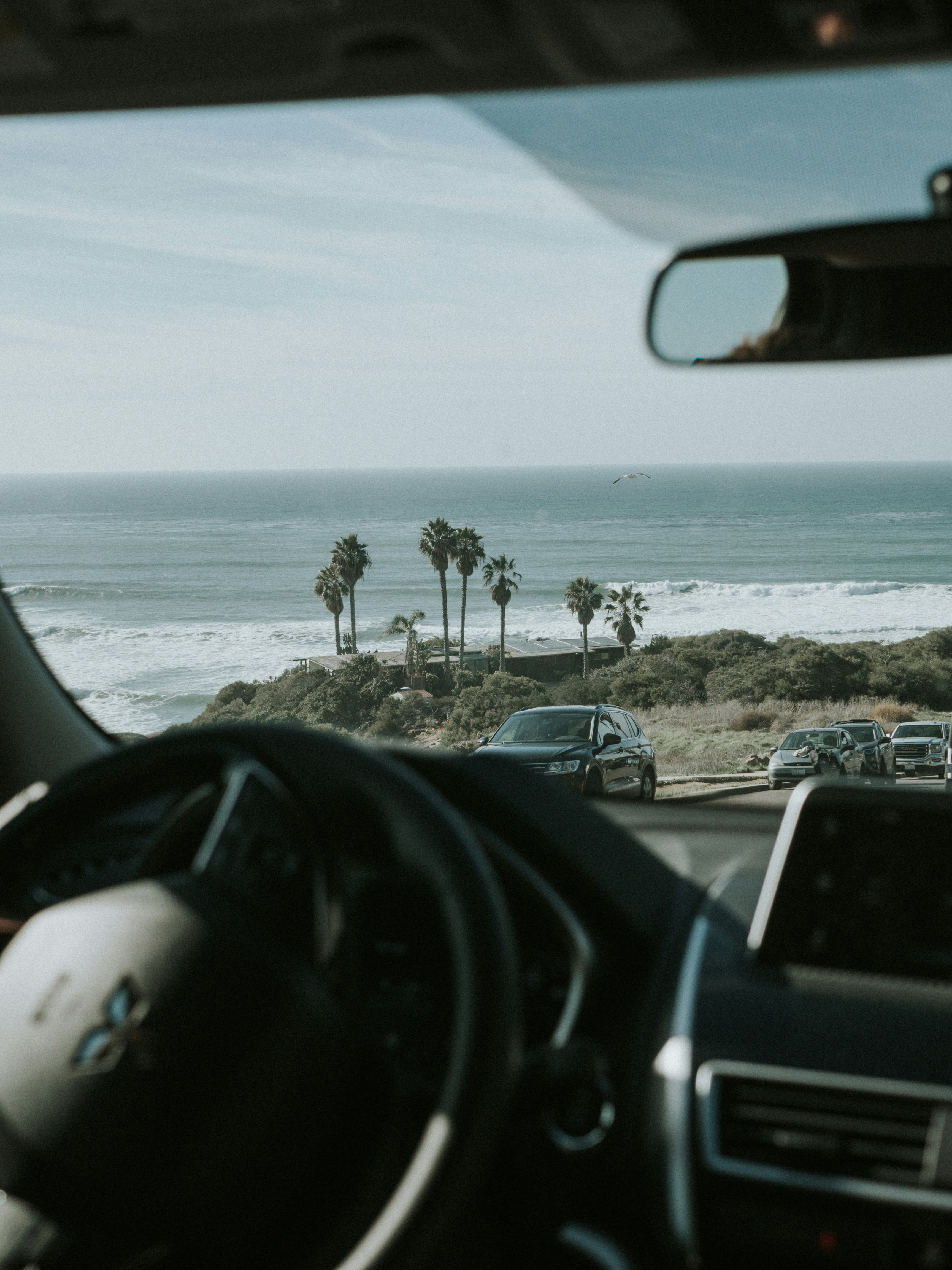 vehicles passing near body of water during daytime