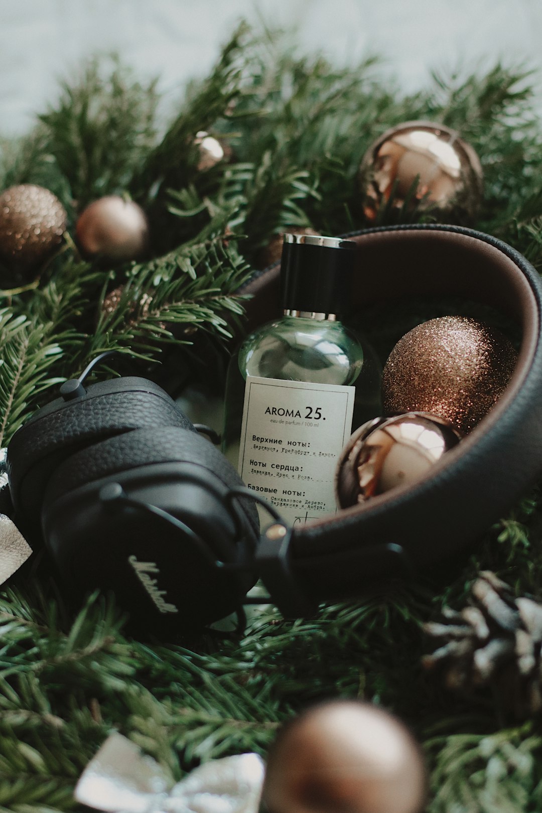 black cordless headphones on green Christmas baubles and garland