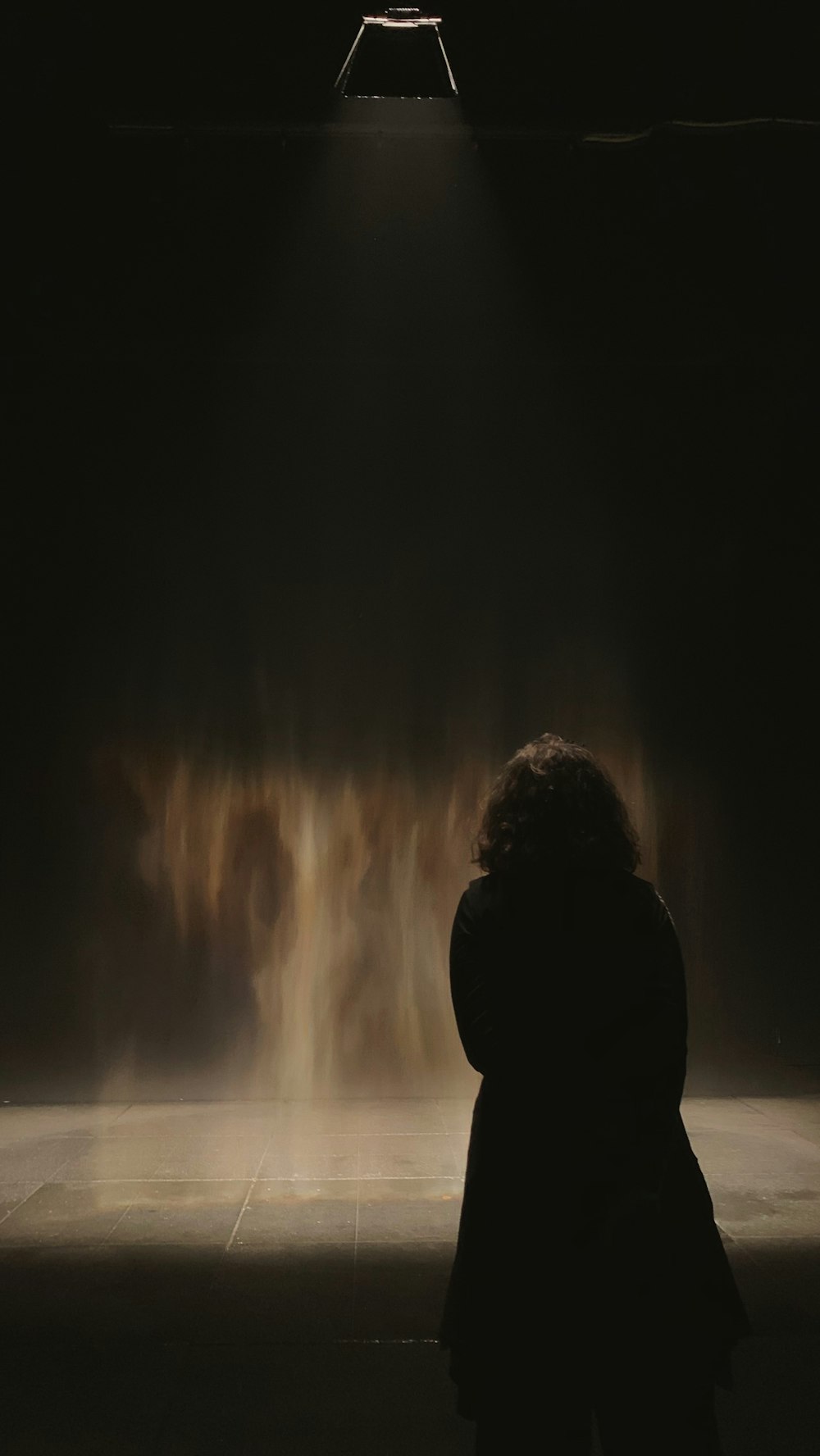 a woman standing in front of a dark room