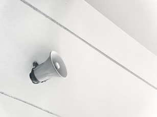 Gray megaphone on white surface.
