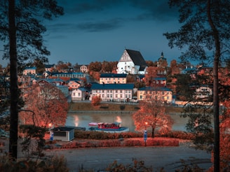 white concrete buildings beside body of water at night