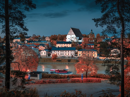 white concrete buildings beside body of water at night in Porvoo Finland