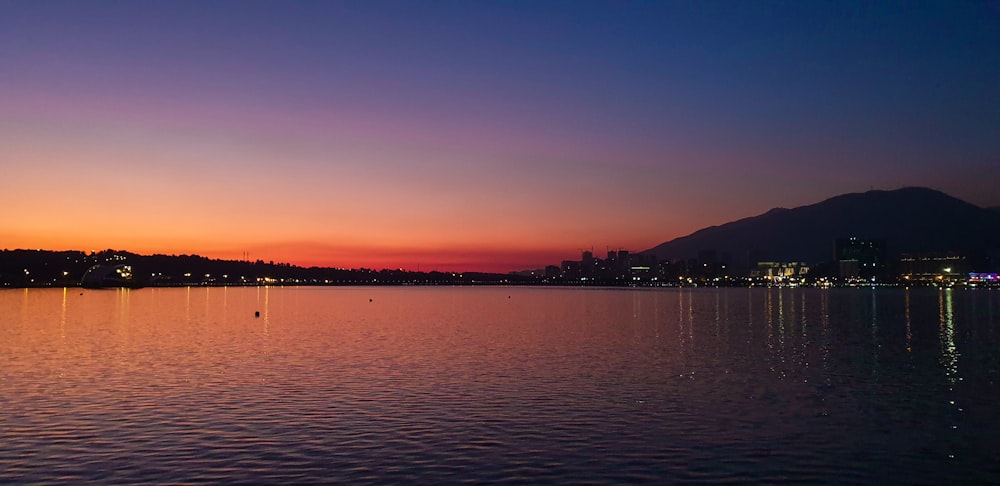 landscape photography of body of water under a purple and orange sky