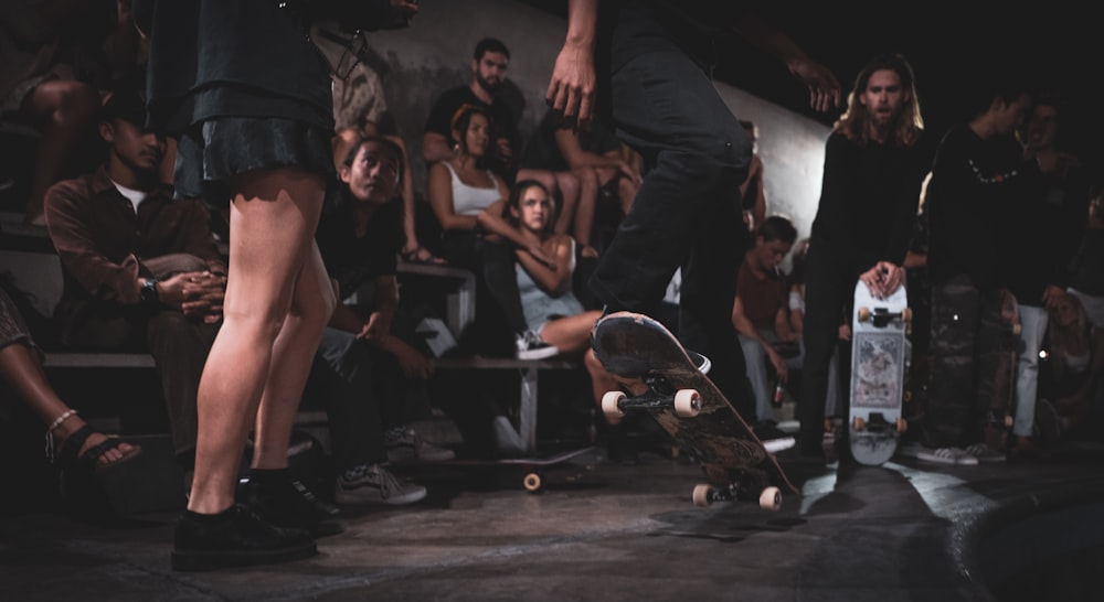 uomini e donne che guardano la persona che fa acrobazia sullo skateboard