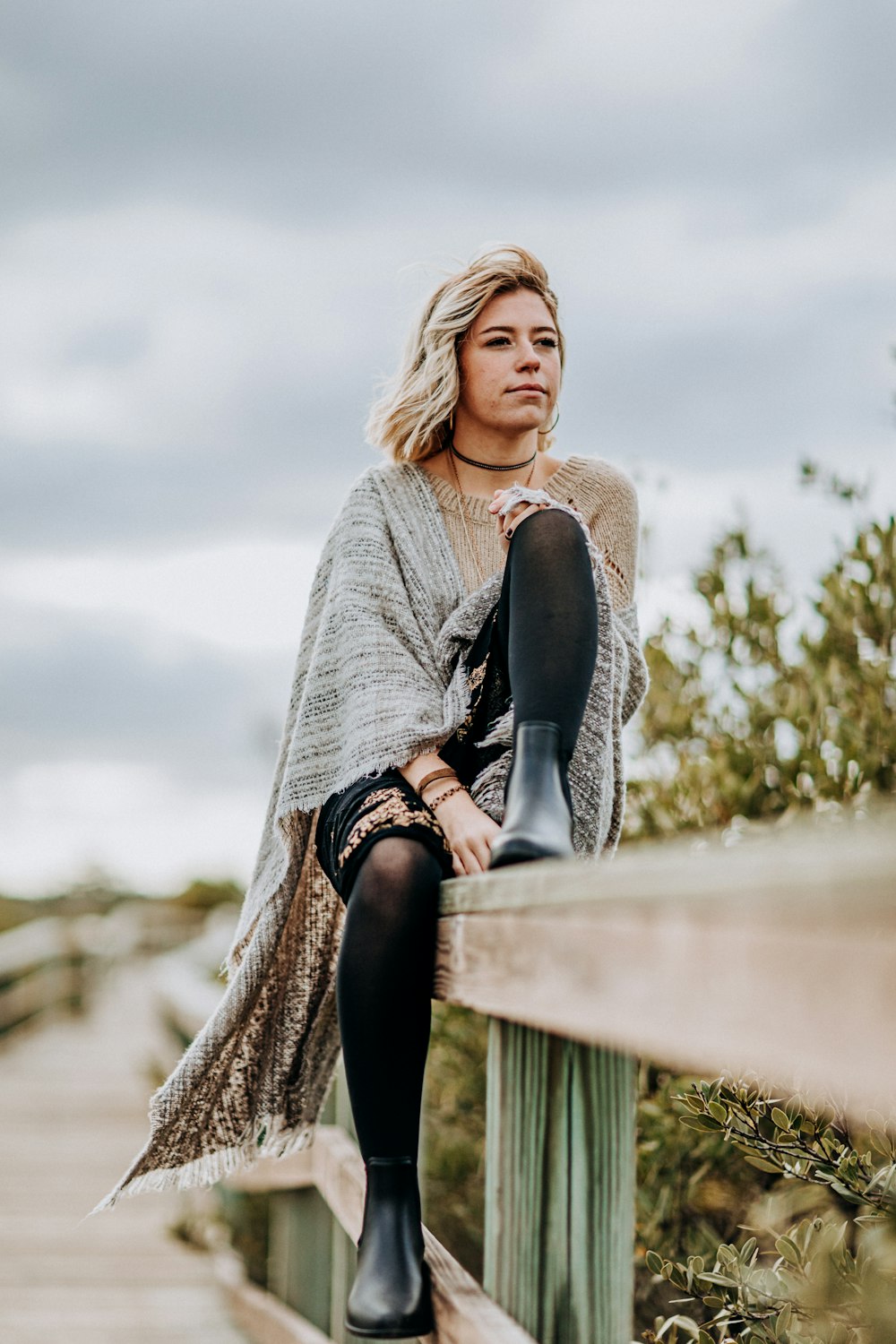 woman sitting on rail during daytime