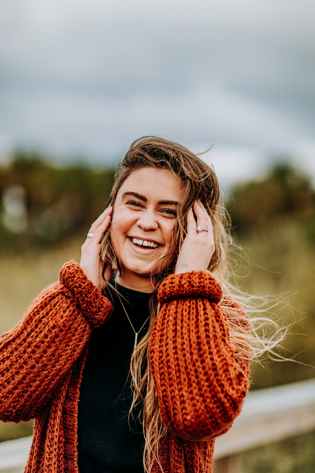 smiling woman wearing brown knit coat