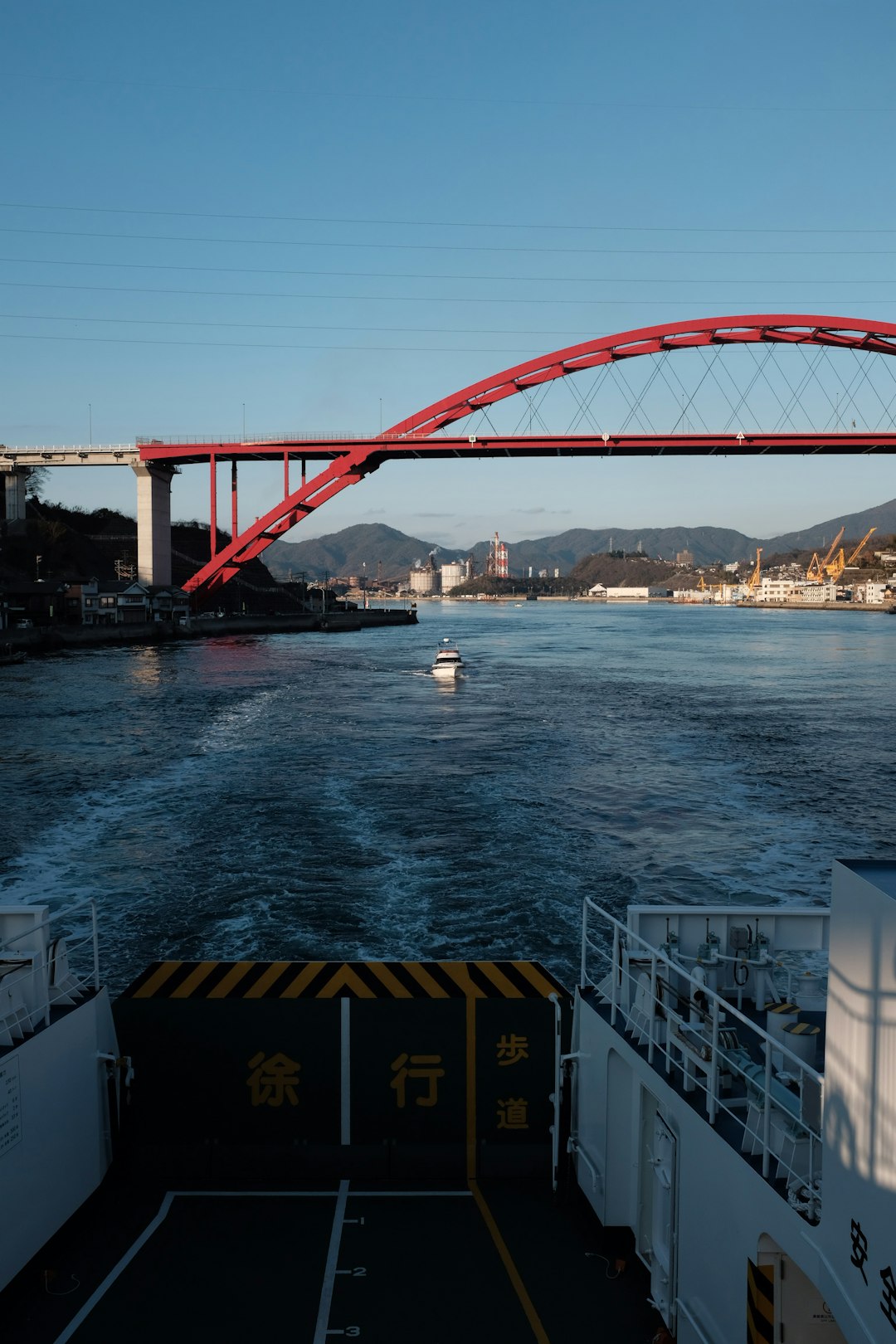 white ship on water near red suspension bridge