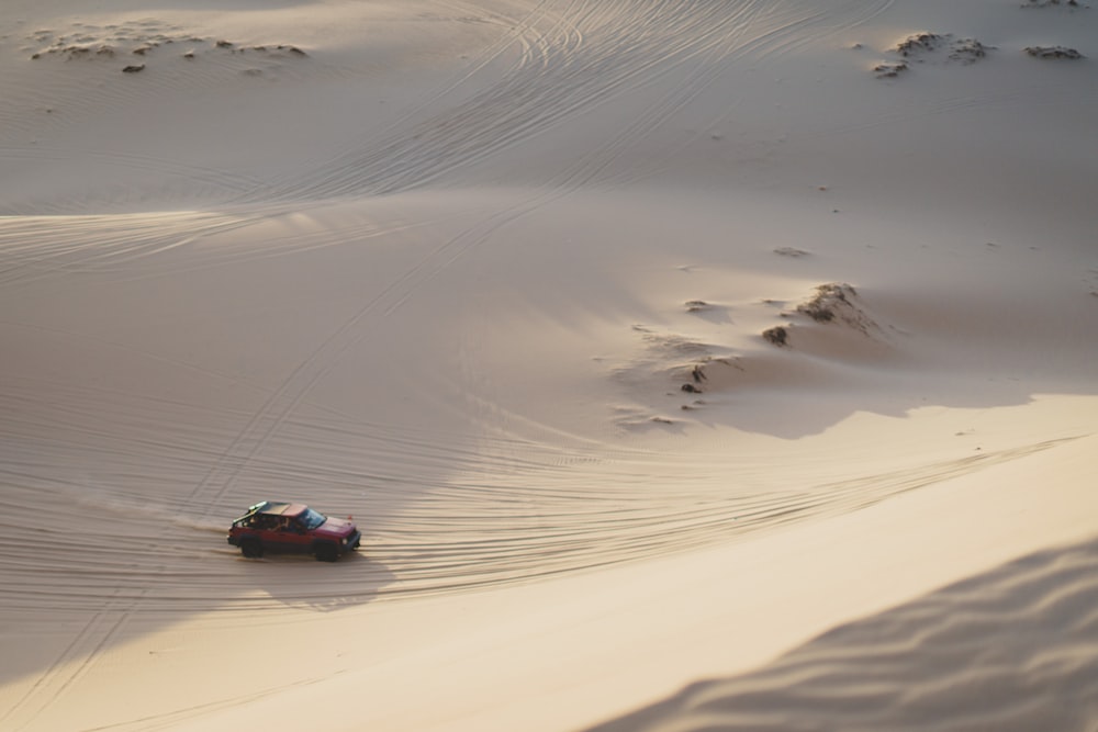 Voiture brune roulant sur le sable du désert