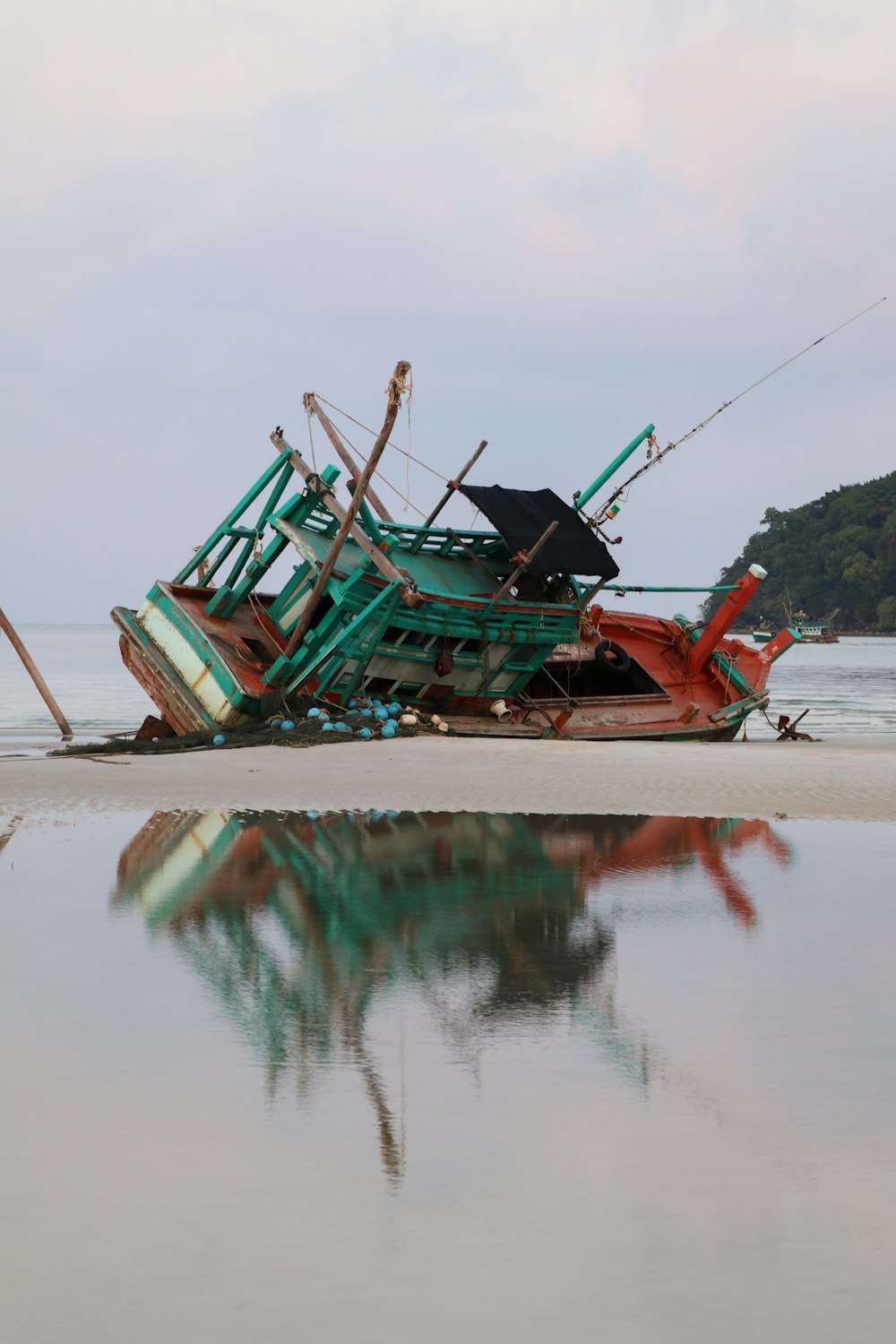 brown and green boat on seashore during daytime