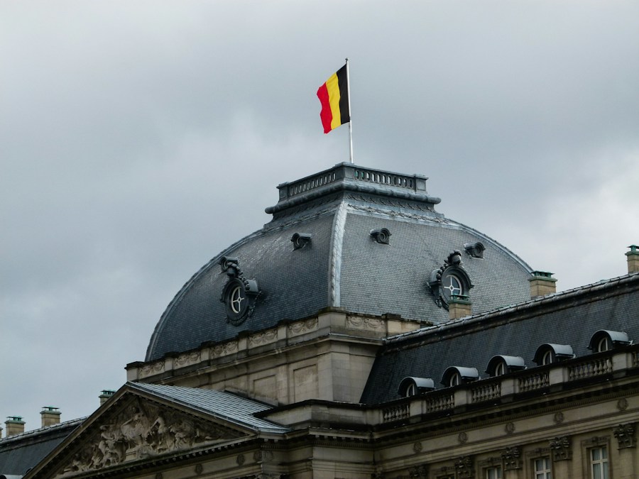 Drapeau belge flottant sur le toit d'un bâtiment, le jour où la Flandre conclut son accord budgétaire et où le fédéral prépare le sien