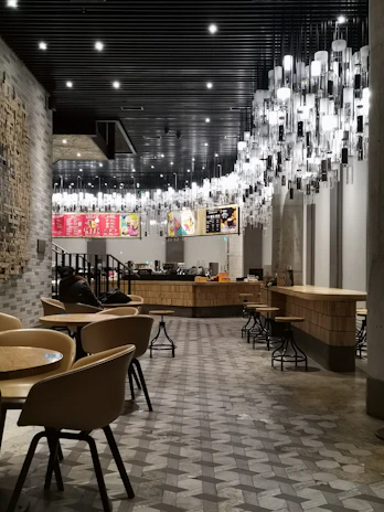A bright, modern café interior showcasing Zahra Kitchen Equipment’s completed turnkey project with customers enjoying their meals.