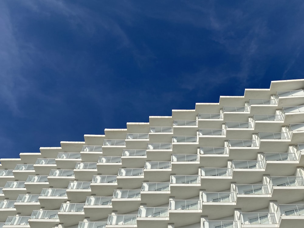 푸른 하늘 아래 흰색 건물의 로우 앵글 사진